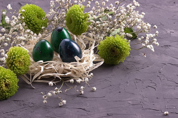 Easter decoration, Easter eggs in the nest on gray concrete background.