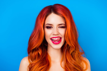 Fototapeta premium close up portrait of funny attractive pretty girl with long ginger fair hair put out her tongue while standing on blue background