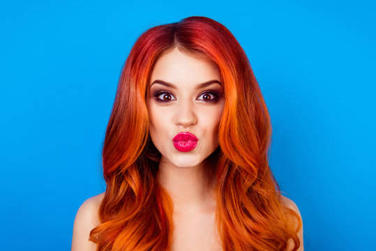 Close-up portrait of funny attractive cute girl with long ginger with dye ombre fair hair pout lips while standing on blue background