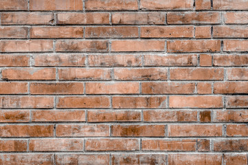 Old red brick wall with cracks and scratches. Horizontal wide brickwall background. Distressed wall with broken bricks texture. Vintage house facade.