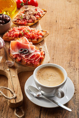 Frothy milky coffee with tostada snacks