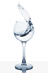 Water splashing out of a tall wine glass