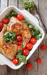 Baked chicken quarter with cherry tomatoes. Roast chicken quarter with the addition of cherry tomatoes. Selective focus