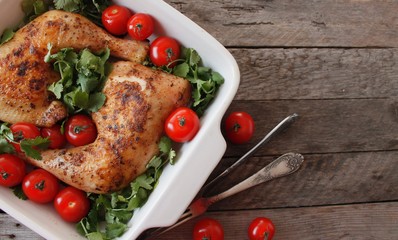 Baked chicken quarter with cherry tomatoes. Roast chicken quarter with the addition of cherry tomatoes. Selective focus