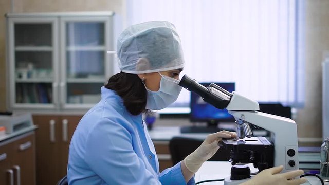 Side view of scientist using microscope