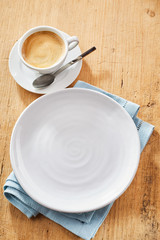 Plate and cup of coffee on table