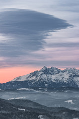 Obraz na płótnie Canvas Poland, landscape, Tatra mountains under cloudy sky during sunrise, winter