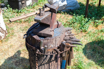 Old anvil with blacksmith tools at the outdoors