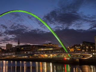 Fototapeta na wymiar Newcastle upon Tyne, England, United Kingdom. The Gateshead Millennium Bridge and its colors during evening time