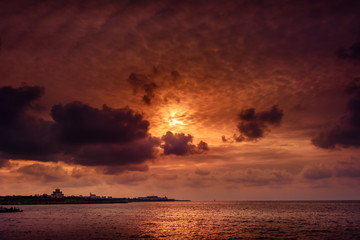 Naklejka premium Gloomy sunset with dark clouds above the calm sea