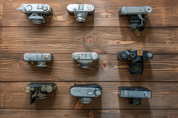 Vintage cameras and lenses on wooden background