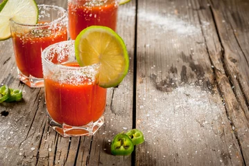 Tuinposter Mexican traditional alcohol drink. Sangrita, with tequila, tomato juice, hot spices, chili and lime.Analogous bloody mary. On rustic wooden table, copy space © ricka_kinamoto