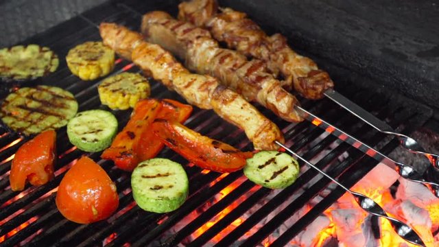 Cooking, food, meat and vegetables are fried over an open fire in the grill