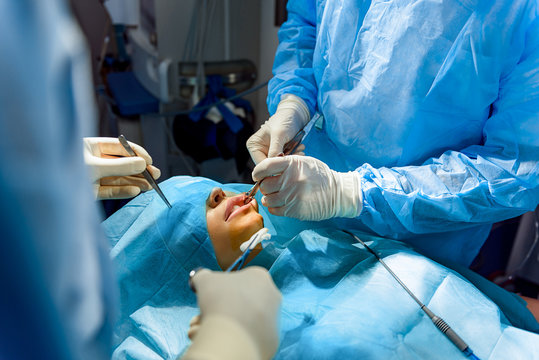 Busy doctors operating female patient