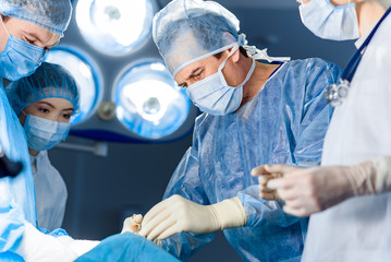 Assembled doctors tensely doing operation