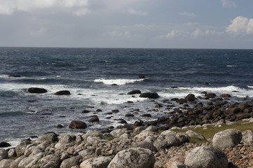 Fototapeta na wymiar Waves hitting rocks at shore