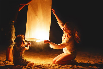 Family send air heavenly flashlight lamp in flight on beach