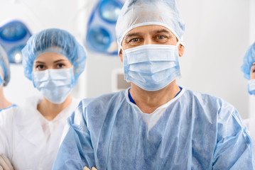 Cheerful male doctor among colleagues