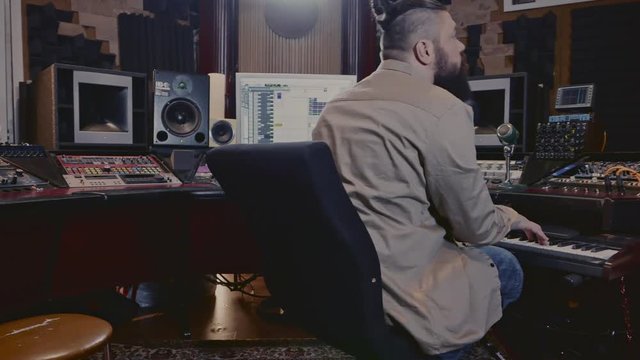 Musicians recording keyboards in boutique recording studio.