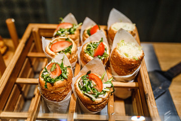 Bread roll with greens, tomato at snack store