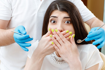 Young scared woman at the dentist office