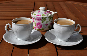 Lifestyle and leisure concept - two cup of coffee with sugar pot on wooden table.