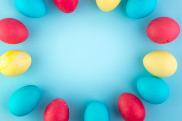 Colored easter eggs and willow on colored background