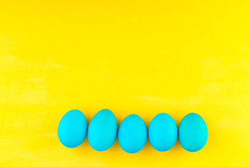 Colored easter eggs and willow on colored background