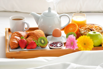 Breakfast tray in bed in hotel room