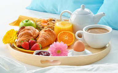 Breakfast tray in bed in hotel room