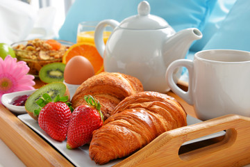 Breakfast tray in bed in hotel room