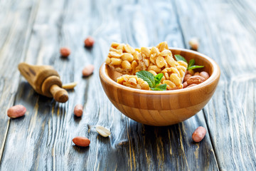 Honey bars from peanuts and mint in a wooden bowl.