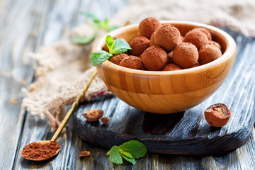 Chocolates and mint in a wooden bowl.