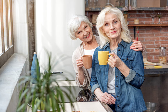 Happy senior women relaxing with cup of hot beverage