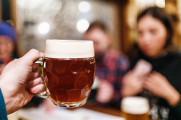 Friends drinking authentic craft beer in czech pub and clinking