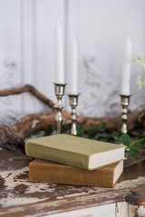 Romantic autumn scenery for photo shoots. Old books, green branch, candles