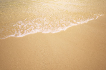Fototapeta na wymiar Soft wave of the sea on the sandy beach for background