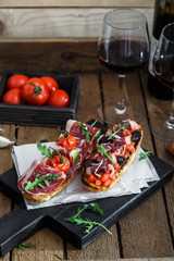 Spanish tapas with slices jamon serrano, salami, olives and cheese cubes on a wooden table. Spanish cuisine