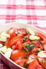 Sliced tomato with young onions salad on the table