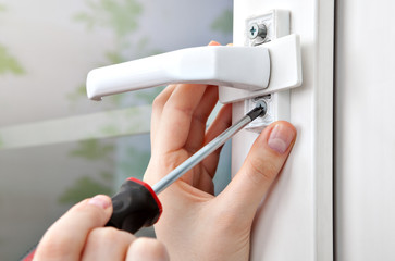Loosening the screw handles plastic window with a hand tool.