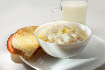 Healthy food - milk rice porridge with milk in a glass and toast (bread)