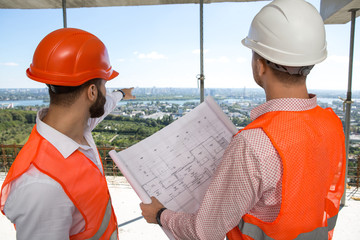 Two male engineers inspecting a construction site
