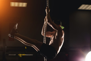 Rope Climb exercise man workout at gym climbing