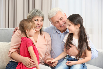 Grand parents and girls on sofa in the room