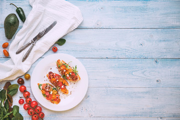 Bruschetta with cheese, basil, arugula and cherry tomatoes