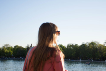 Fototapeta na wymiar Girl looking at the lake in a blurred plan