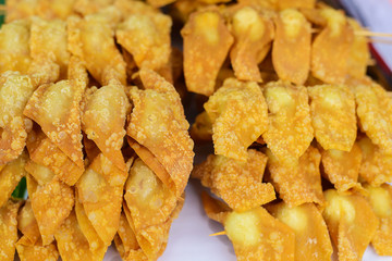 deep fried wonton's on a stick, at a food market in Bangkok, Thailand.