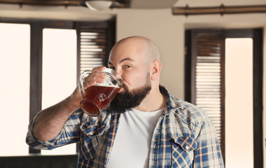 Bearded man drinking beer in pub