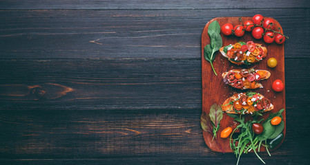 Bruschetta with cheese, basil, arugula and cherry tomatoes