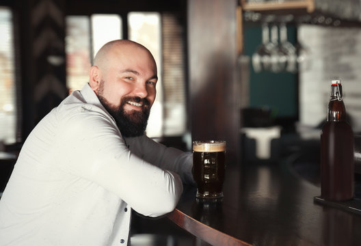 Man with glass of beer in pub